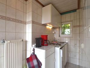 eine kleine Küche mit Kühlschrank und Spüle in der Unterkunft Charming bungalow with garden in Tabarz in Cabarz