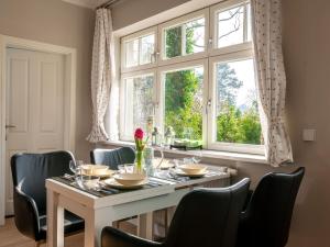 uma sala de jantar com uma mesa e cadeiras e uma janela em Striking Apartment near Lake in Wannsee em Berlim