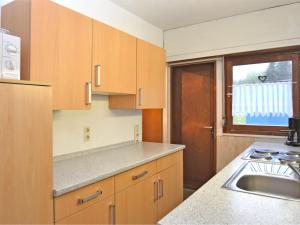 a kitchen with wooden cabinets and a sink and a window at Classy Holiday Home in Wolfshagen with Fenced Garden in Hahnenklee-Bockswiese