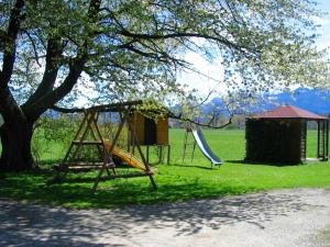two swings and a house under a tree at Bayerischer Rückzugsort in der Nähe des Chiemsees in Übersee