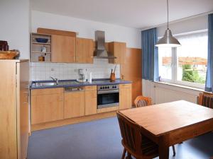a kitchen with wooden cabinets and a wooden table with a wooden tableablish at Apartment with private terrace in H ddingen in Bad Wildungen