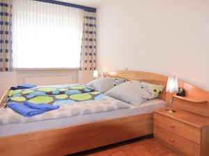 a bedroom with a wooden bed with a window at Apartment with private terrace in H ddingen in Bad Wildungen