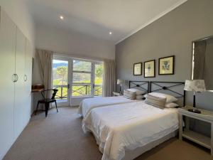 a bedroom with two beds and a large window at Silvermist Wine Estate in Cape Town