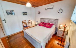 a bedroom with a bed with red pillows on it at Beautiful Home In Riantec With 3 Bedrooms in Riantec