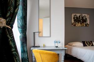 a bedroom with a desk and a bed and a mirror at Hôtel & Gastronomie - La Table de l'Europe in Villeréal