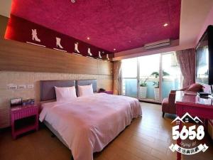 高雄的住宿－R8環保商旅，一间卧室设有一张粉红色天花板的大床