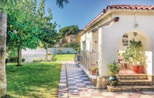 a house with a garden and a patio at 3 Bedroom Nice Home In Francàs in Comarruga +15 photos