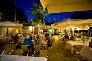 a group of people sitting at a restaurant at night at Residence Delle Rose in Tremosine Sul Garda