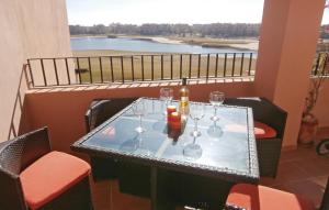 a table with wine glasses and a bottle on a balcony at Beautiful Apartment In Torre-pacheco With Outdoor Swimming Pool in Los Martínez
