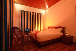Un dormitorio con una cama, una silla y una ventana en Entire Villa at the Heart of the Wayanad Forest., en Kutta