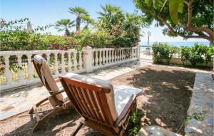 two chairs sitting next to a fence and the ocean at 5 Bedroom Nice Home In Santa Pola in Santa Pola