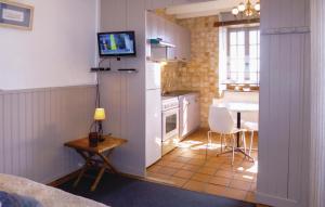 uma pequena cozinha com uma mesa e uma televisão em Stunning Home In Morsalines With 1 Bedrooms And Wifi em Morsalines