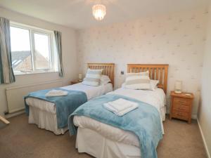 a bedroom with two beds and a window at Number Six in Burniston