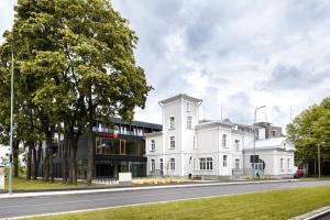 a white building on the side of a road at Cozy city center studioapartment, Free parking in Pärnu