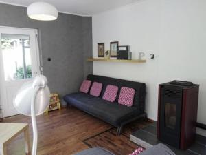 uma sala de estar com um sofá preto e almofadas cor-de-rosa em Holiday home with terrace in Sauerland em Brilon