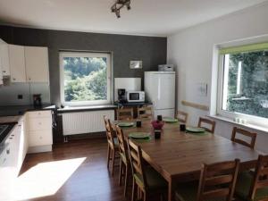 uma cozinha com uma grande mesa de madeira e cadeiras em Holiday home with terrace in Sauerland em Brilon