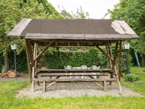 a wooden picnic shelter with two chairs under it at Apartment in Thuringia with garden 