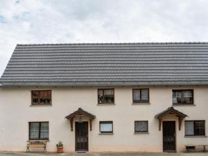 a white house with a black roof at Apartment in Thuringia with garden 
