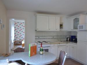 a kitchen with white cabinets and a table with a bottle of wine at Luxurious Apartment in Sch now with Sauna in Bernau bei Berlin