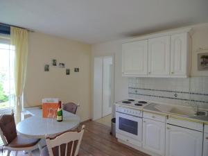 a kitchen with white cabinets and a table with a bottle of wine at Luxurious Apartment in Sch now with Sauna in Bernau bei Berlin