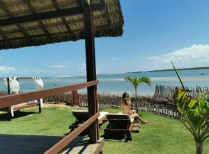 a woman sitting on a chair looking out at the ocean at Beach Bungalow-KiteAliCori , Macapa' in Luis Correia +20 photos