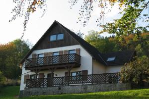uma grande casa branca com uma varanda em Nice holiday home near ski area em Medebach