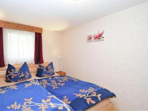 una camera da letto con un letto con lenzuola blu e un fiore rosa sul muro di Idyllic holiday home in Neinstedt near forest a Thale