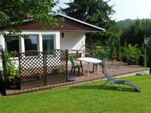 a patio with a table and chairs in a yard at Idyllic holiday home in Neinstedt near forest in Thale