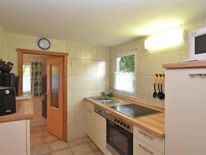 una cucina con lavandino e piano cottura forno superiore di Idyllic holiday home in Neinstedt near forest a Thale