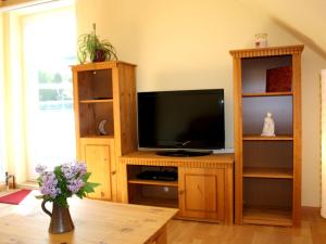 ein Wohnzimmer mit einem TV in einem hölzernen Unterhaltungszentrum in der Unterkunft Apartment in a quiet location with balcony in Herrischried