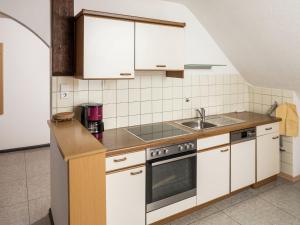 a kitchen with white cabinets and a sink at Apartment in a quiet location with balcony in Herrischried