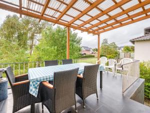 einen Tisch und Stühle auf einer Terrasse mit einer Pergola in der Unterkunft Magnificent Villa in Medebach near Ski Area in Medebach