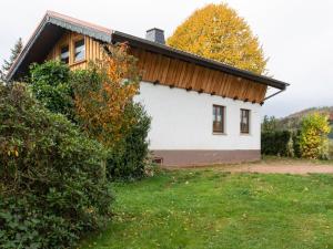 a white house with a wooden roof at Holiday home in the Thuringian Forest in Wutha-Farnroda