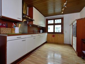 een keuken met witte kasten en een houten vloer bij Cozy holiday home with WiFi in Hochsauerland in Elpe