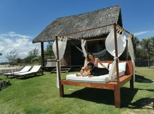a woman laying on a bed with a dog on a swing at Beach Bungalow-KiteAliCori , Macapa' in Luis Correia