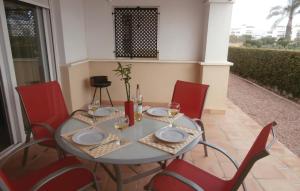 uma mesa com cadeiras vermelhas, pratos e copos de vinho em Beautiful Home In Roldn With Outdoor Swimming Pool em Roldán