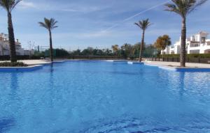 uma grande piscina azul com palmeiras em Beautiful Home In Roldn With Outdoor Swimming Pool em Roldán