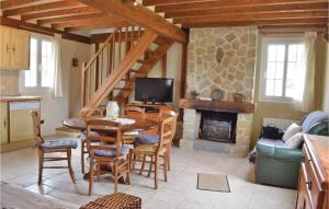a living room with a table and a fireplace at Amazing Home In La Cambe With 2 Bedrooms And Wifi in La Cambe