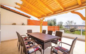 una sala da pranzo con tavolo e sedie in legno di 3 Bedroom Nice Apartment In Barbat a Barbat na Rabu