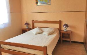 a bedroom with a bed with two nightstands and two lamps at Two-Bedroom Holiday Home In La Tranche-Sur-Mer in La Tranche-sur-Mer +4 photos