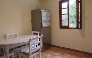 a kitchen with a table and a stainless steel refrigerator at Nice Apartment In Furiani With 2 Bedrooms And Wifi in Furiani