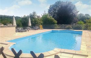 a swimming pool with chairs and umbrellas in a yard at Amazing Home In Granges Dans With 2 Bedrooms, Wifi And Outdoor Swimming Pool in Granges-dʼAns