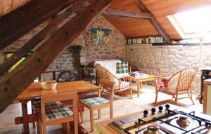 En un edificio hay una sala de estar con mesas y sillas de madera. en Stunning Home In Melrand With Kitchenette, en Melrand