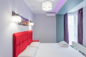 a room with a bed with a red head board at Harmony Residence in Bucharest