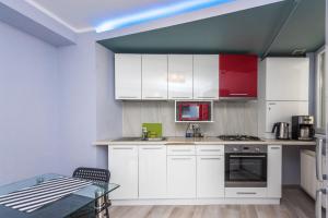 a kitchen with red and white cabinets and a table at Harmony Residence in Bucharest