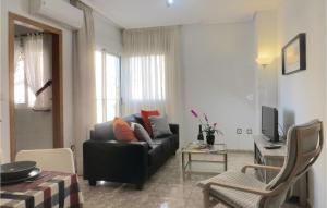 ein Wohnzimmer mit einem Sofa und einem Tisch in der Unterkunft Beautiful Apartment In Torrevieja With Kitchen in Torrevieja