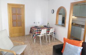 ein Wohnzimmer mit einem Tisch und Stühlen sowie eine Küche in der Unterkunft Beautiful Apartment In Torrevieja With Kitchen in Torrevieja