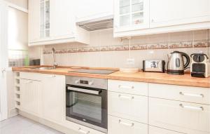 a kitchen with white cabinets and a stove top oven at Nice Apartment In Rivera Del Sol in La Cala de Mijas