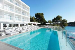 a hotel room with a pool and a pool table at Grupotel Ibiza Beach Resort - Adults Only in Portinatx