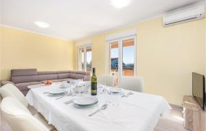 uma sala de jantar com uma mesa branca e um sofá em Awesome Apartment In Cavle With Wifi em Čavle